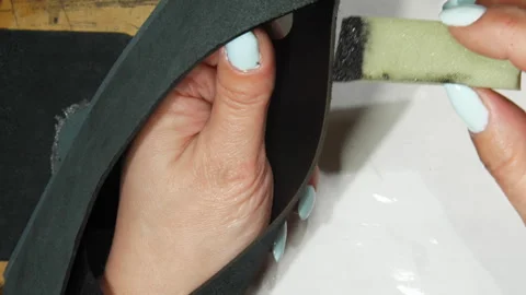 Tailor hands carefully apply paint on edge of leather detail Stock Footage 283376365