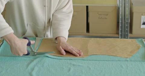 Tailor hands cutting material with scissors on table. Designer working at studio Vídeo Stock 200955425