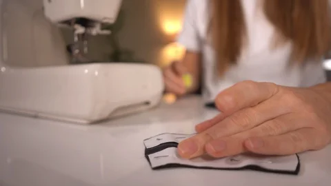 Tailor hands making a pattern on the black fabric before sew protective mask Stock Footage 127848879