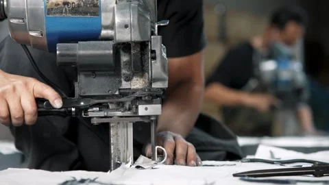 Tailor Hands Operating Electric Rotary Cutter Machine through Fabric Layers Video stock 344086763