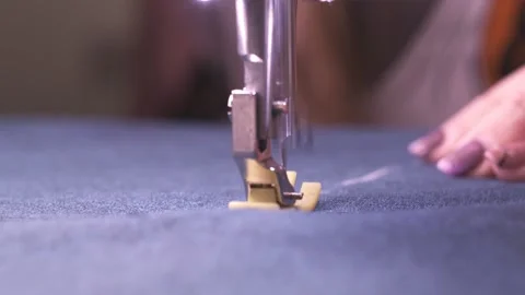 Tailor hands sewing at automatic sewing machine. Female worker push blue textile Video stock 151140743