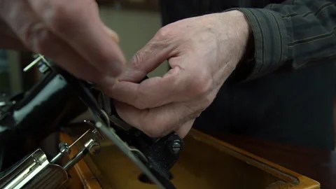 Tailor hands turn screwdriver fixing sewing machine parts Stock Footage 130693117