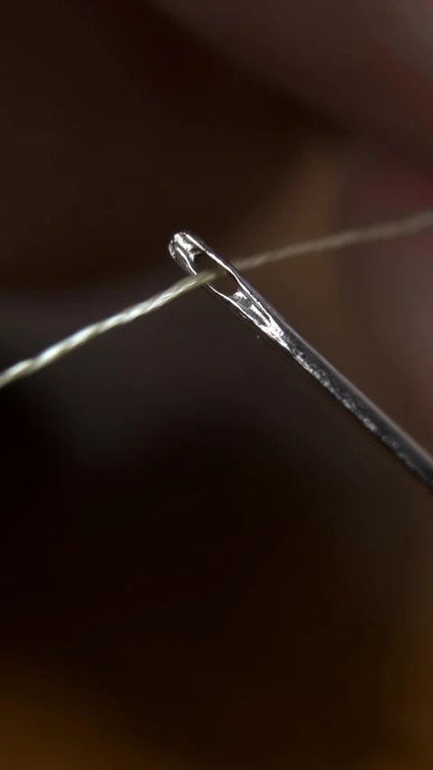 Tailor inserting sewing thread into a needle hole, needle eye. Vídeo Stock 312315573