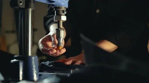 A tailor inserts metal rivets on jeans with a special machine Stock Footage 221281057