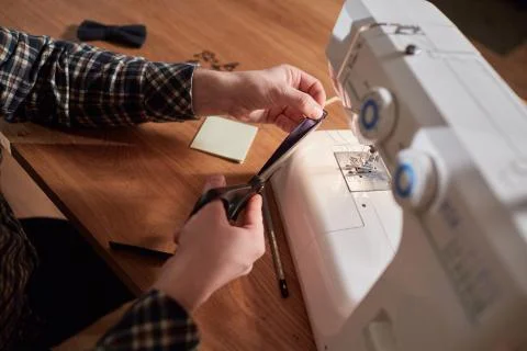 Tailor makes bow ties of woolen fabric. Work with sewing machine in a textile Stock Photos