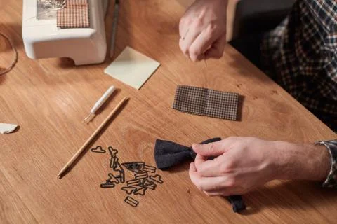 Tailor makes bow ties of woolen fabric. Work with sewing machine in a textile Stock Photos