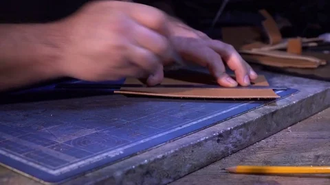 The tailor makes a wallet purse made from hand-made leather in the atelier Видео 85419361