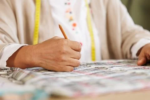 Tailor Marking Checkered Fabric Pattern With Pencil In Creative Workshop Cl.. Stock Photos
