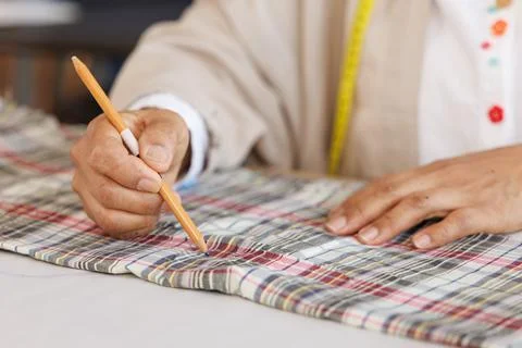 Tailor Marking Pattern On Plaid Fabric In Professional Workshop Close Up Shot Stock Photos