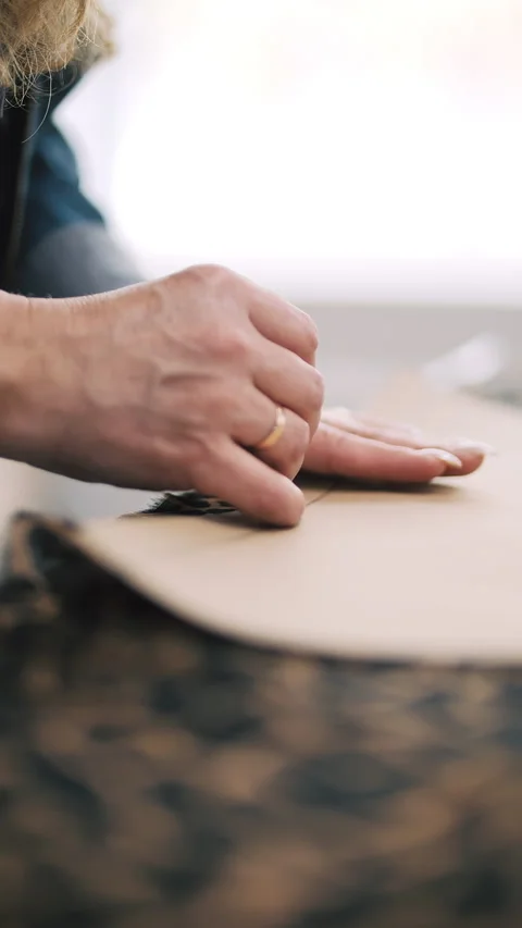 Tailor marking sewing pattern on leopard fabric Stock Footage 308724284