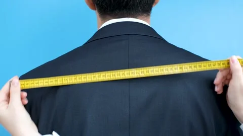 The tailor measures the suit with a measuring tape close-up, back view. Stock Footage 280954822