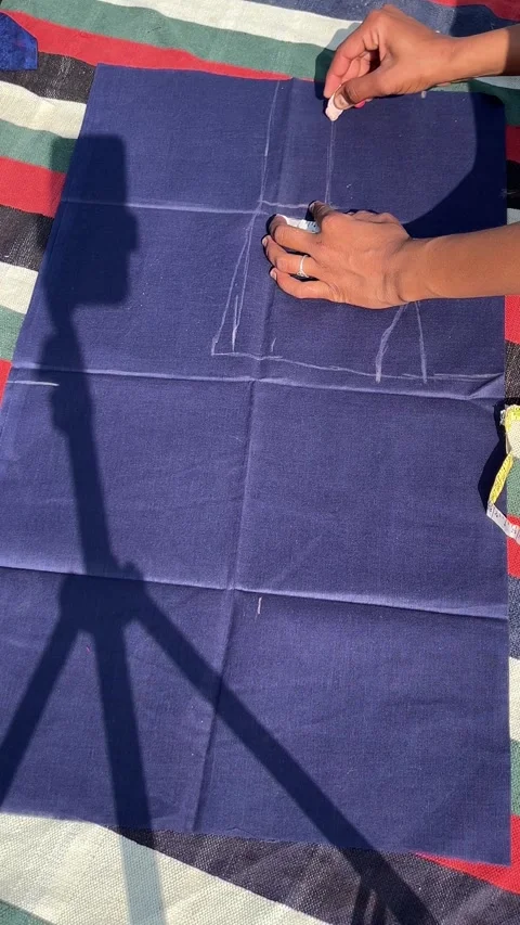 Tailor Measuring and Marking Blue Fabric with Chalk and Tape Measure Stockbeeldmateriaal 324893356