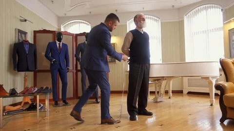Tailor measuring client for custom made garment Stock Footage