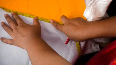 Tailor measuring garment on the table Stock Photos