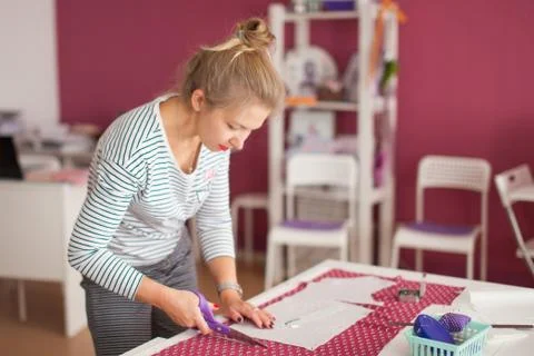 Tailor measuring textile material. young woman seamstress making pattern on f Stock Photos