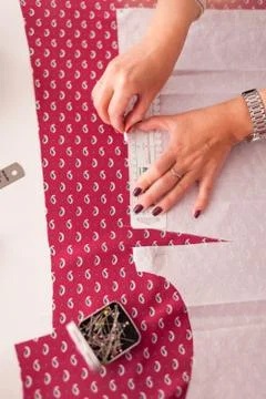 Tailor measuring textile material. young woman seamstress making pattern on f Stock Photos