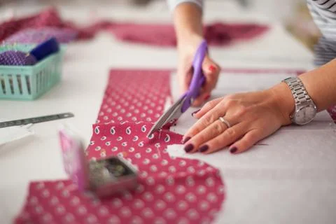 Tailor measuring textile material. young woman seamstress making pattern on f Stock Photos