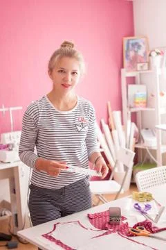 Tailor measuring textile material. young woman seamstress making pattern on f Stock Photos