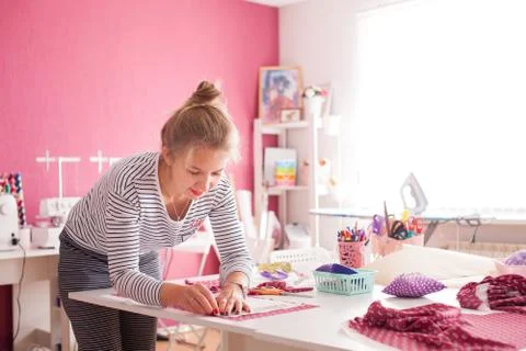 Tailor measuring textile material. young woman seamstress making pattern on f Foto stock