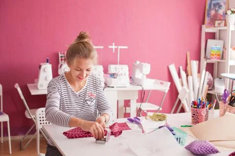 Tailor measuring textile material. young woman seamstress making pattern on f Stock Photos