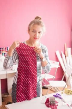 Tailor measuring textile material. young woman seamstress making pattern on f Stock Photos