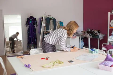 Tailor measuring textile material. young woman seamstress making pattern on f Foto stock