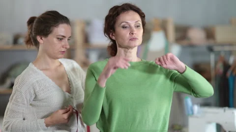 Tailor measuring woman client in sewing studio for custom garment Stock Footage 330402071