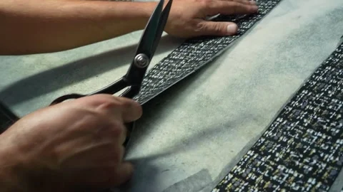 Tailor Meticulously Cutting Fabric with Scissors in a Leather Factory Stock Footage 322057766