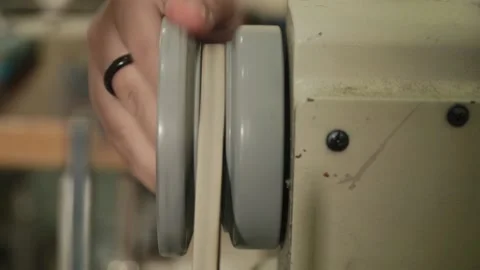 Tailor moving the wheel of sewing machine to start it's functioning. 動画素材 149452949