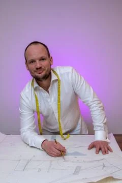 Tailor portrait in atelier posing with bespoke jacket suit pattern on designe Stock Photos