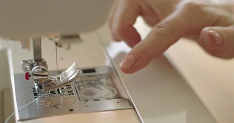 Tailor putting thread at needle of sewing machine while preparing for the sewing Stock Footage 202515578