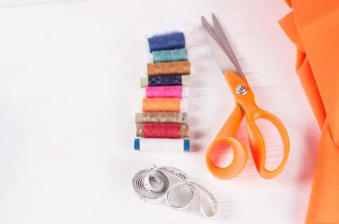Tailor scissors, inch, centimeter tape, sewing thread on white wooden  backgr Stock Photos