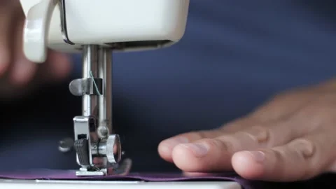 Tailor sew on sewing machine, close up with selective focus Stock Footage 156384800