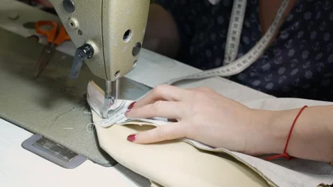 Tailor sewing clothes with a machine in a workshop creating custom-made apparel Stock Footage 339754749