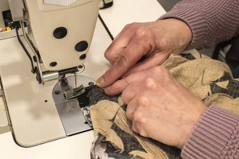 Tailor sewing fabric on machine Stockfoto's