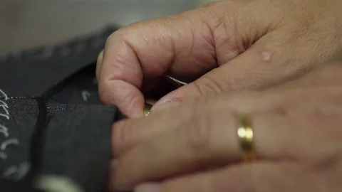 Tailor sewing pants with needle and thread Stock Footage 79812707