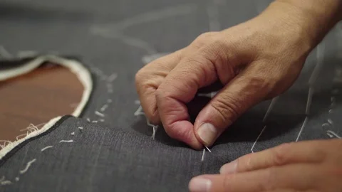 Tailor sewing pants with needle and thread slow motion Stock Footage 79813564