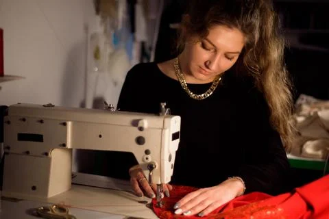 Tailor sewing on sewing machine. Strain the tissue. Stock Photos