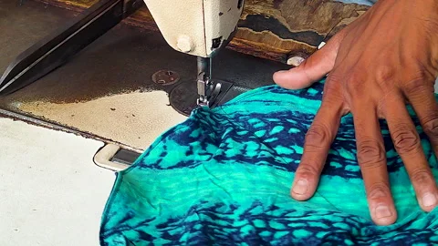 Tailor Sewing Turquoise Patterned Fabric on Industrial Sewing Machine Stock Footage 342574486
