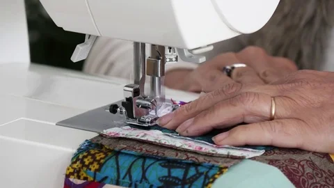 Tailor sews on the sewing machine multi colored patchwork fabric Video stock 80113669