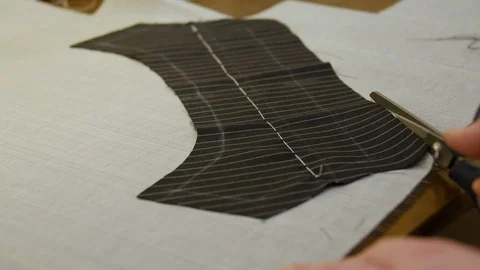 Tailor with shears cutting under-collar canvas. Melton cloth is traditionally Video stock 127334122