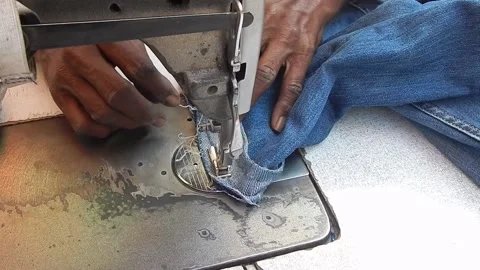 Tailor stitching jeans pant in day light Stock Footage 149305622