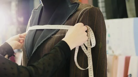 Tailor taking measures with measuring tape on a mannequin Stock Footage 106231808