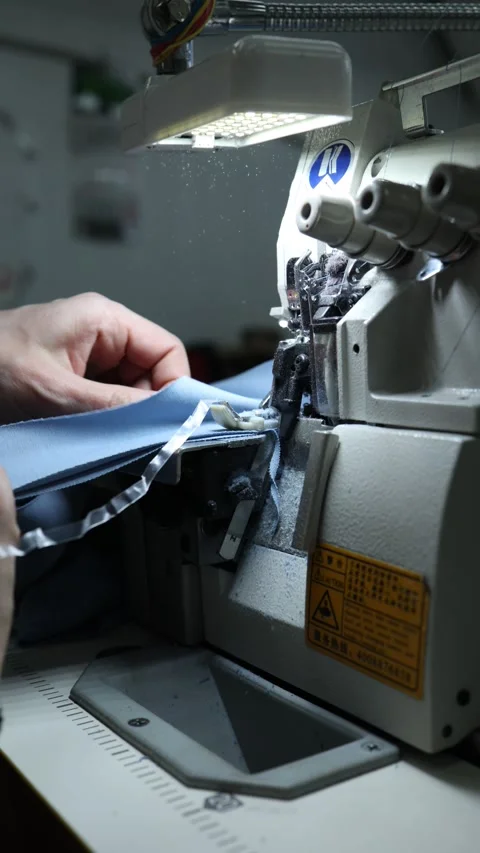Tailor threading industrial sewing machine needle with precision close-up in Stock Footage 300204669