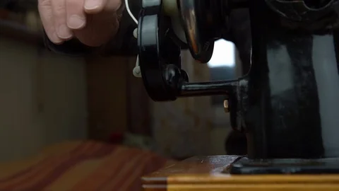 Tailor turns hand wheel located on machine to adjust needle Video stock 129149773