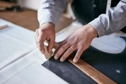 Tailor using chalk and ruler to outline pattern on fabric 스톡 사진