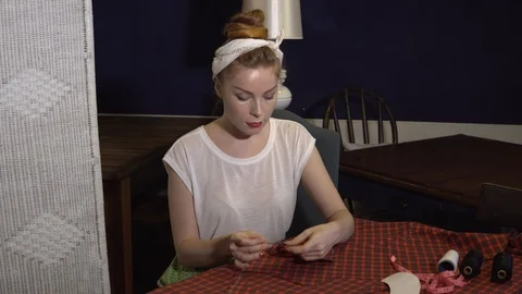 A tailor using needle and thread to hand sew the fabric to create clothers Stock Footage 88772917