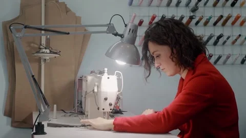 A tailor at work sews fabric on a sewing machine. Modeling and Sewing of clothes Stock Footage 165958628