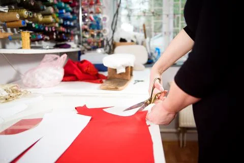 Tailor working with cloth at table in atelier. Stock Photos