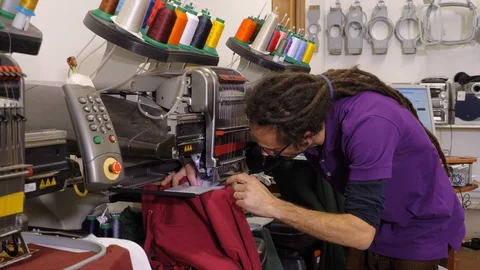 Tailor working in his studio with industrial embroidery machine Stock Footage 119957950